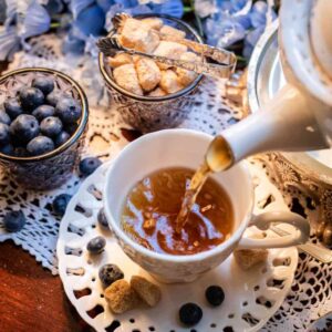 Online Tea Shop Loose Leaf Black Tea - Darcy and Elizabeth Pouring in Teacup Fruity Blueberry Cinnamon Iced